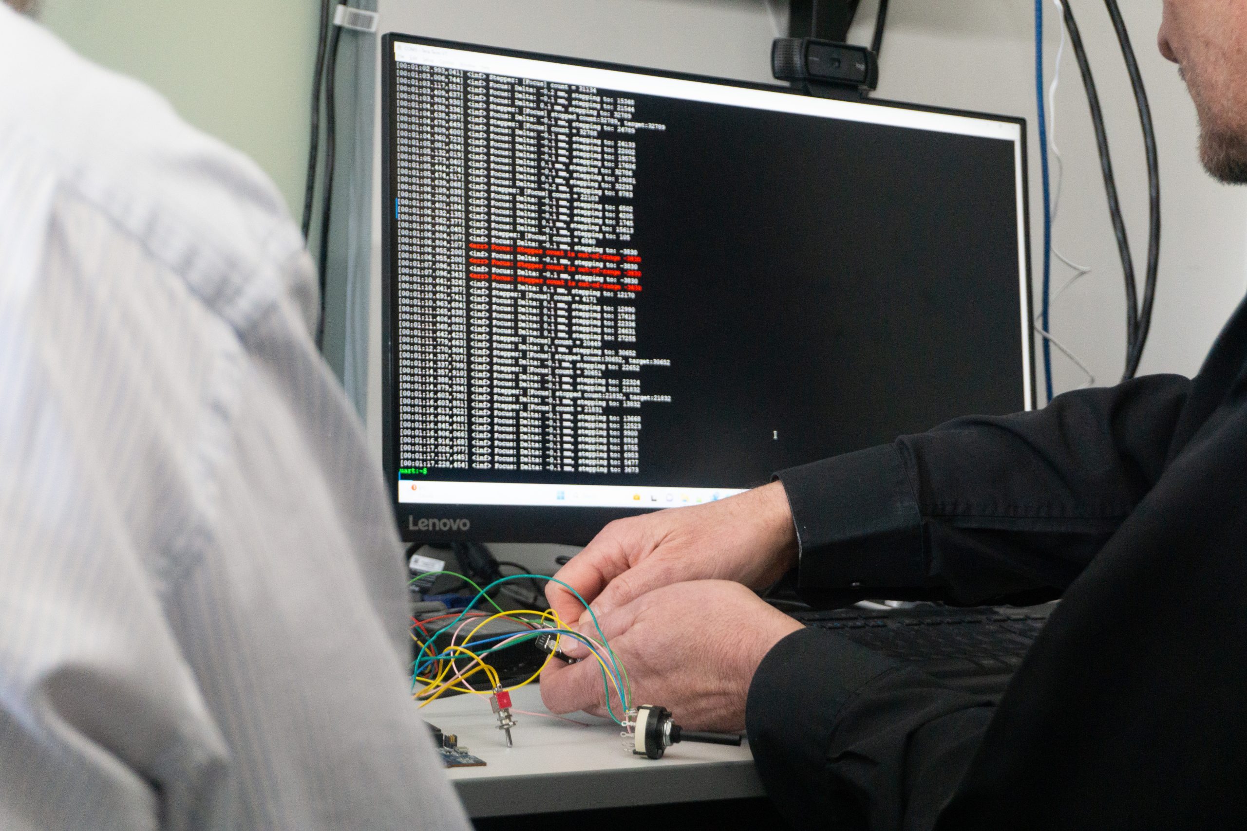Software Testing, with two designers working infront of a monitor displaying code - Product Design & Development - Embedded Software Development Services - Service