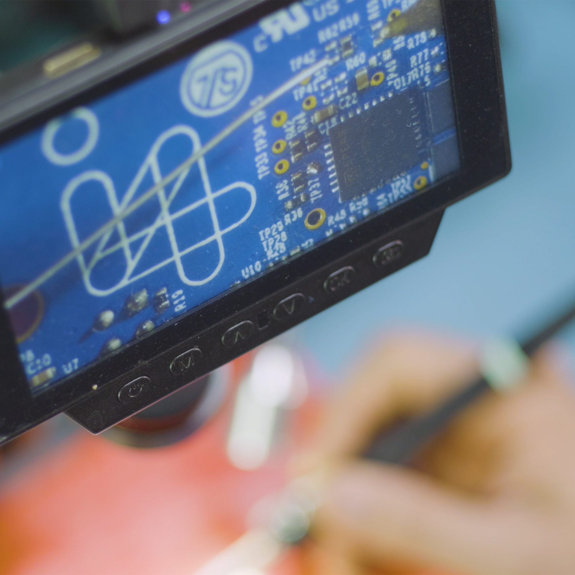 electronics engineer soldering in i4PD lab under microscope - electronics product design
